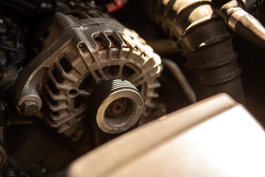 Close-up view of car alternator during engine repair, highlighting auto maintenance.