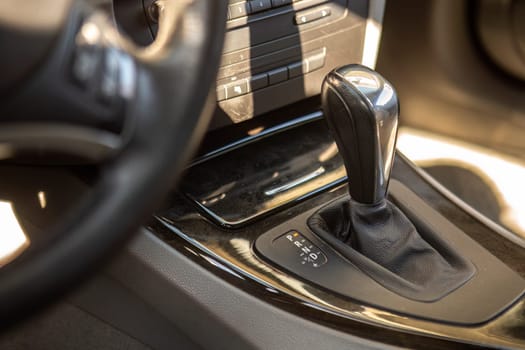 Close-up of a modern car's automatic gearshift lever, showcasing sleek vehicle design.