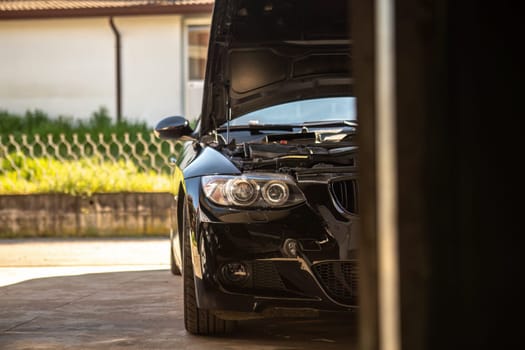 A sleek sports car undergoing repair in a garage, highlighting automotive maintenance expertise.