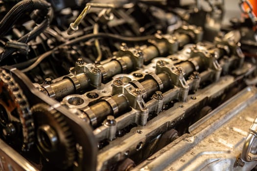 Close-up of a car's disassembled engine showing camshaft detail during workshop repair.