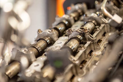 Close-up of a car's disassembled engine showing camshaft detail during workshop repair.