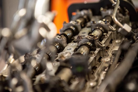 Close-up of a car's disassembled engine showing camshaft detail during workshop repair.