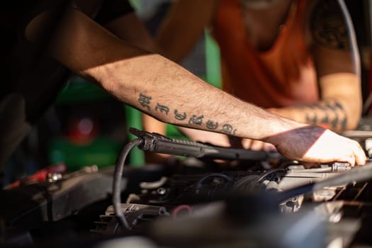 Close-up of a mechanic's dirty hands while repairing a car engine, showcasing hard work.