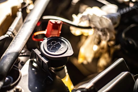 Close-up of the windshield washer fluid reservoir in a car engine, essential for visibility.