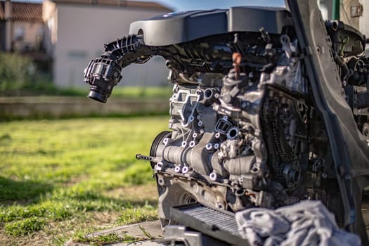 An old, broken engine left outside a workshop, depicting abandonment and repair needs.