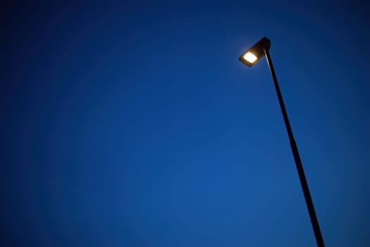 A lone street lamp casts a warm glow on the surrounding darkness, symbolizing solitude and peace.