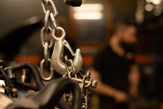 Detailed image of a stretched chain with a metal hook under tension, symbolizing strength.