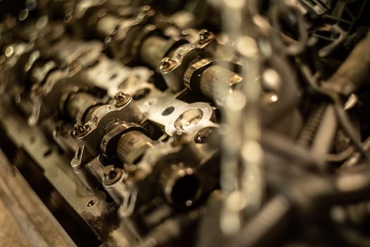 Close-up of a car's disassembled engine showing camshaft detail during workshop repair.