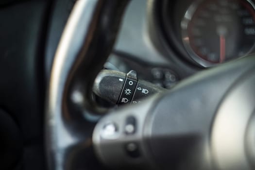 Detailed view of a car's headlight switch lever, highlighting the ignition and lighting control.