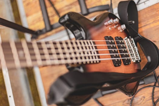 An electric bass guitar is securely hanging on a wall, displaying its sleek design and strings.