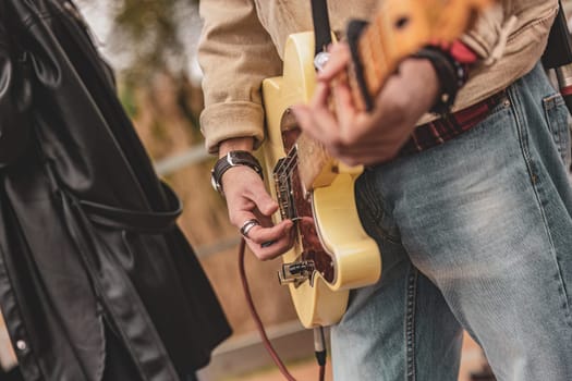 A man standing next to another man, holding a guitar.