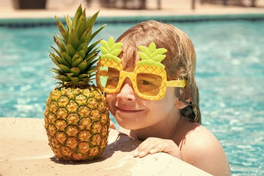 Happy child playing in swimming pool. Summer kids vacation. Little kid boy relaxing in a pool having fun during summer vacation