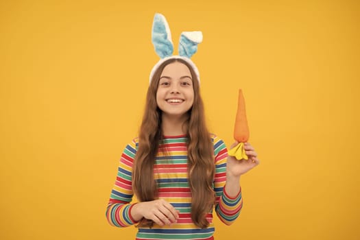 happy easter kid girl in rabbit bunny ears hold carrot for holiday, easter bunny.