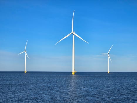 Windmill park in the ocean, green energy Energy transition, zero emissions, carbon neutral, Earth day concept, windmills isolated at sea in the Netherlands.