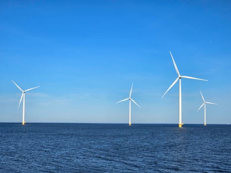 Windmill park in the ocean, Energy transition, zero emissions, carbon neutral, Earth day concept, windmills isolated at sea in the Netherlands.