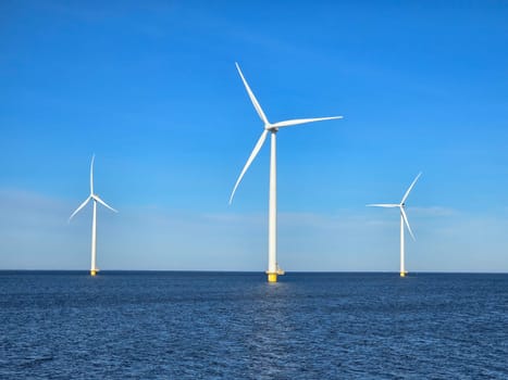 Windmill park in the ocean, view of windmill turbines on a Dutch dike generating green energy electrically, windmills isolated at sea in the Netherlands. Energy transition, zero emissions
