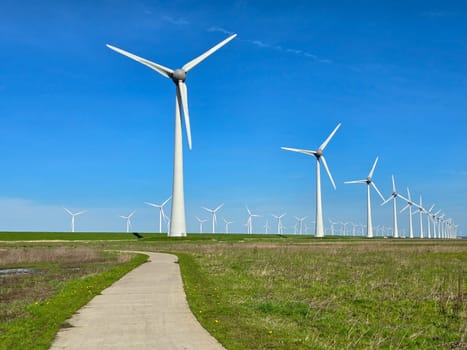 windmill turbines on a Dutch dike generating green energy electrically windmills isolated at sea in the Netherlands.