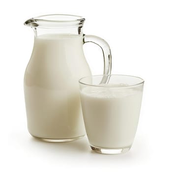 High-quality image showcasing fresh milk in a clear glass and a transparent pitcher, isolated on a white background, symbolizing health and purity.