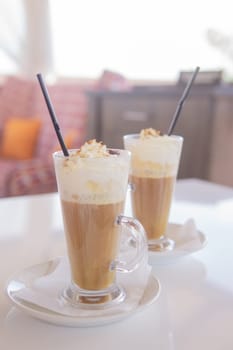 coffee is served in a tall glass glass with a straw. The concept of coffee drinks from the bar menu.