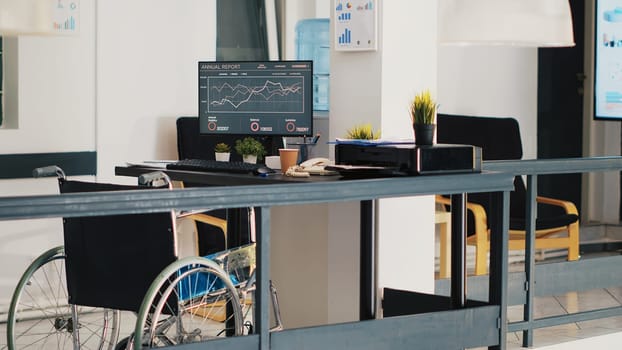 Wheelchair in inclusive accounting department office with forecasting profit analysis on laptop. Economic annual revenue trends on notebook in workspace with accessibility for workers, panning shot