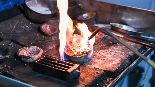 Craftsman heats metal on a blazing forge in an peruvian workshop