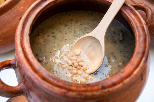 Clay pot with traditional Peruvian food called seco con frejoles