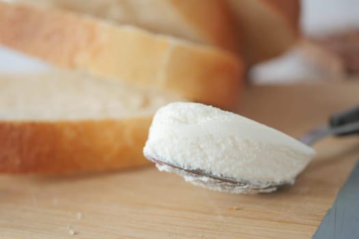 Slice of bread and cream cheese on white background