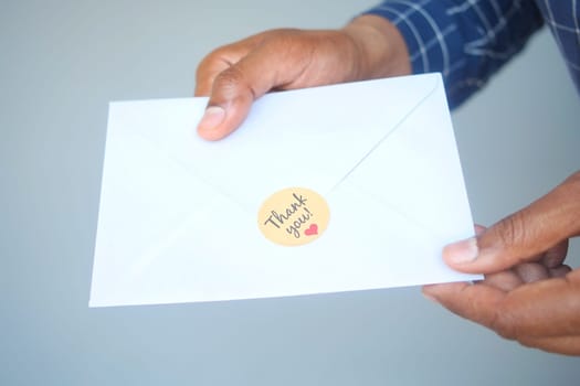 close up of man hand reading a thank you letter .