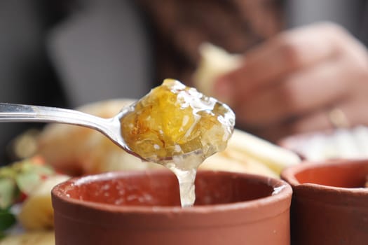 woman hand spoon picks fresh honey .