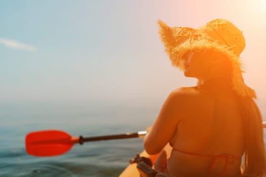 A woman wearing a straw hat is paddling a canoe on a sunny day. Scene is relaxed and carefree, as the woman enjoys her time on the water