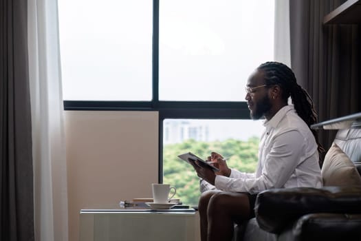 Young African American businessman dressed casually Work from your laptop while you're on vacation by working from home..