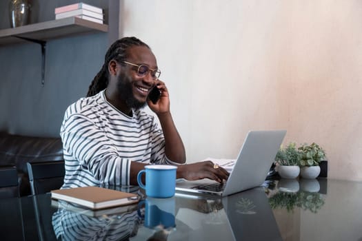 Professional man working remote from home with technology. African American male has a business meeting on an audio call phone.