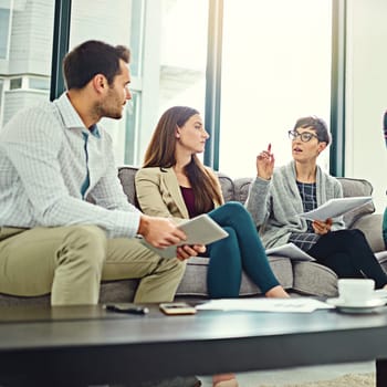 Collaboration, papers and employee talking on sofa for communication, teamwork and conversation in office. Planning, ideas and employees with tablet or technology for startup project with discussion.