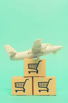 White model airplane lands on blue background from most famous countries around the world with boxes of goods behind. An idea of air freight transportation, global parcel forwarding, international shipping