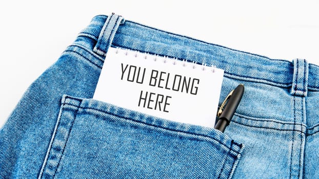 Diversity, business, inclusion and belonging concept. You belong here symbol on a notebook from a pocket next to a pen