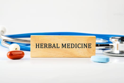 Medical concept. HERBAL MEDICINE text on a wooden block on a gray background