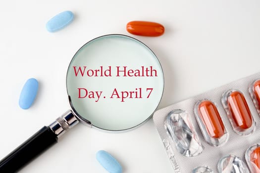 Medical concept. World health day concept. World Health Day 7 April. through a magnifying glass on a white background next to pills, medicines