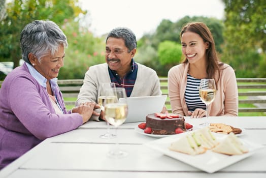 Senior, couple and romance, outdoor and tablet for celebration of anniversary of parents with champagne. Summer, relax and weekend, cake and lunch for brunch in backyard or garden, woman and family.