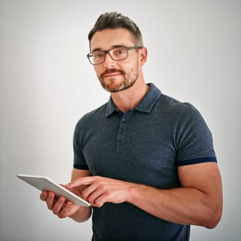 Portrait, man and confident with tablet in studio on white background for ecommerce or network as technology specialist. Mature person, businessman and smile for digital communication and connection.