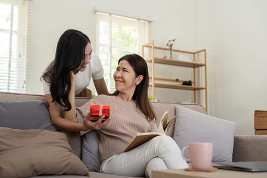 Happy mother day. Beautiful young daughter woman and mother with gift box at home. Enjoy family concept.