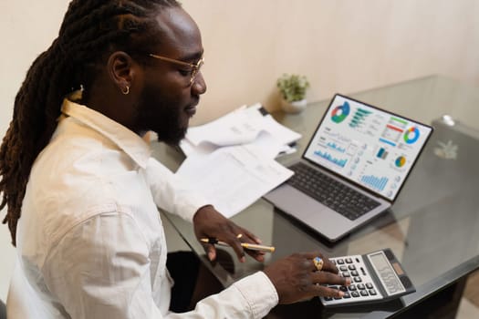 Businesswoman using a calculator to calculate numbers on a company's financial documents, she is analyzing historical financial data to plan how to grow the company. Financial concept.