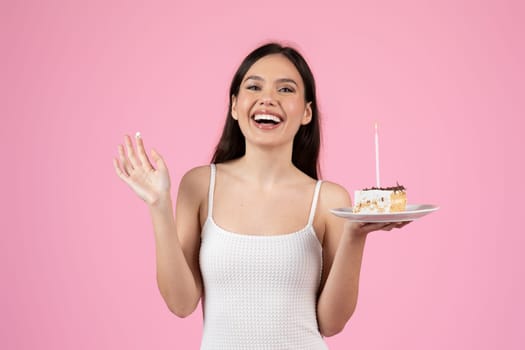 Exuberant lady laughing whilst holding a birthday cake, set against a pink backdrop of European summer, isolated and fit for generation z