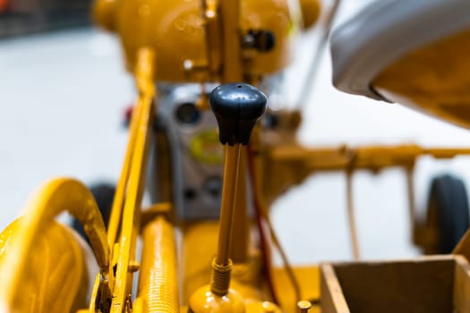 Small yellow tractor in an exhibition, closeup details, wheels