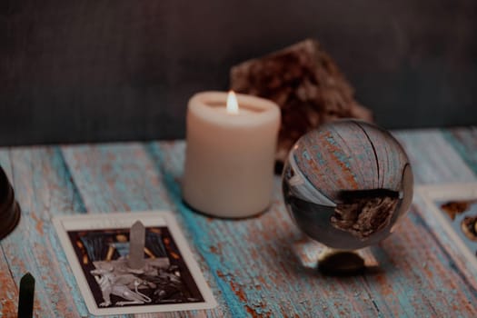 A tarot card reading session depicted with candles, crystals, and mystical accessories on a rustic wooden table