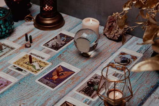 A tarot card reading session depicted with candles, crystals, and mystical accessories on a rustic wooden table