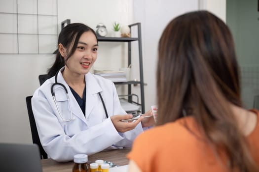 Female doctor and elderly female patient consulting about health problems in clinic.