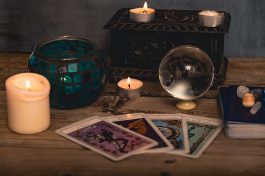 Tarot cards including The Fool and The Lovers alongside crystals and candles on a textured wooden table