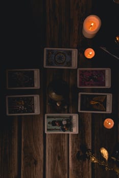 Tarot cards including The Fool and The Lovers alongside crystals and candles on a textured wooden table