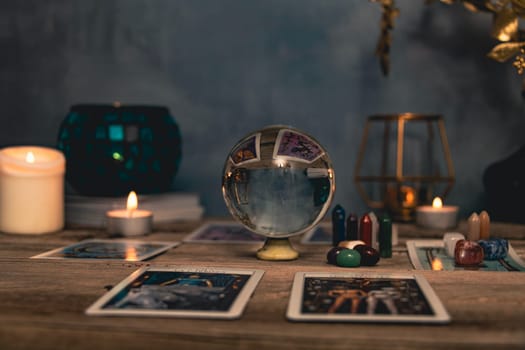 Tarot cards including The Fool and The Lovers alongside crystals and candles on a textured wooden table