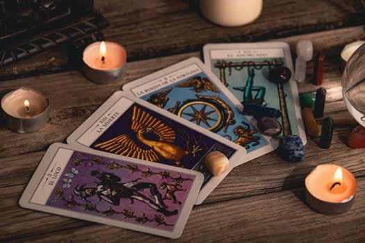 Tarot cards including The Fool and The Lovers alongside crystals and candles on a textured wooden table